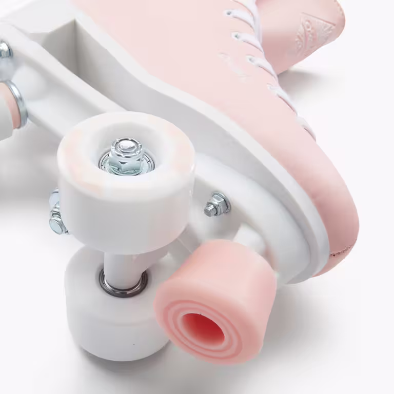 A close up of a white and pink wheel on a peach roller skate