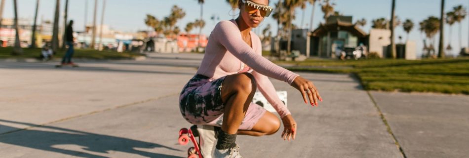 a woman crouching down, wearing roller skates