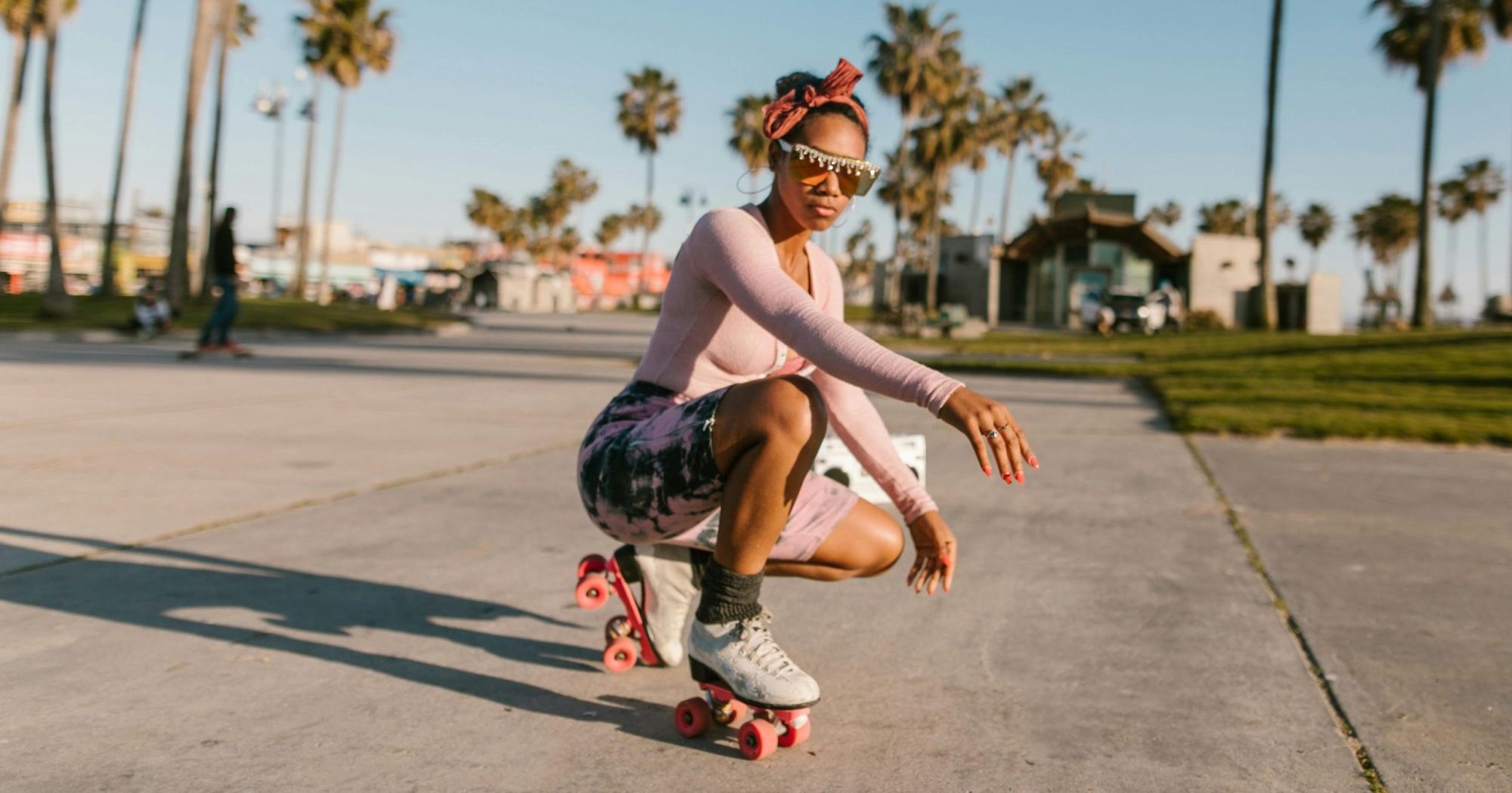 a woman crouching down, wearing roller skates
